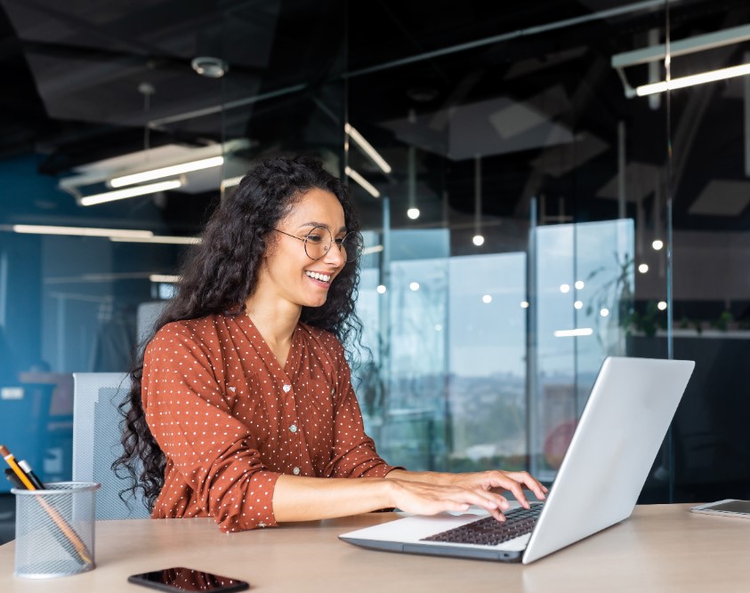 una mujer sonriente que trabaja en su oficina.